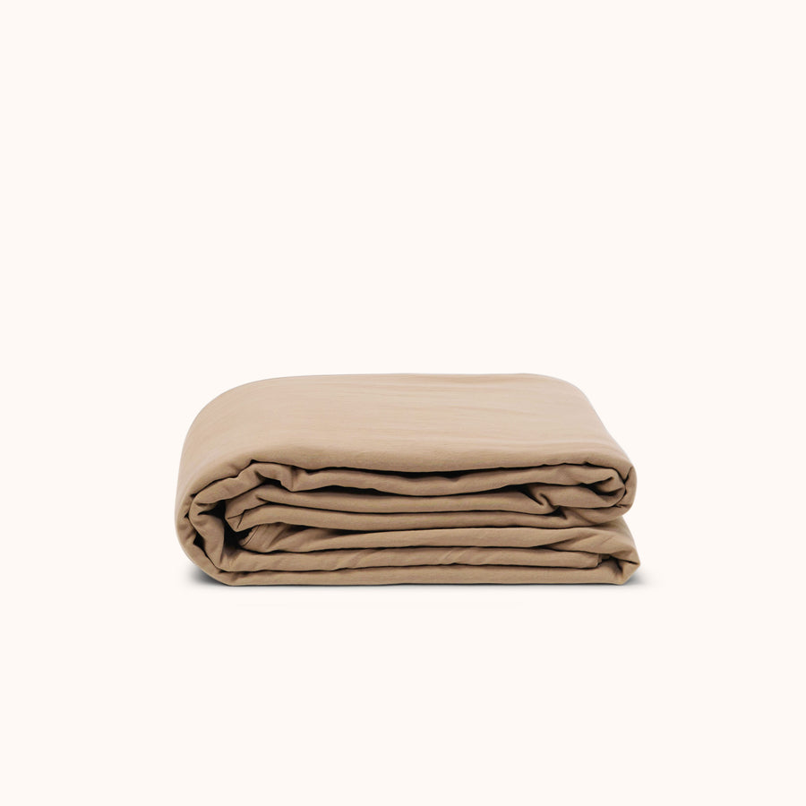 Folded beige duvet cover on a white background
