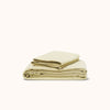 Folded organic matte sateen Límon sateen sheet set on a white background