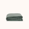 A folded duvet cover in a matte green color against a white background