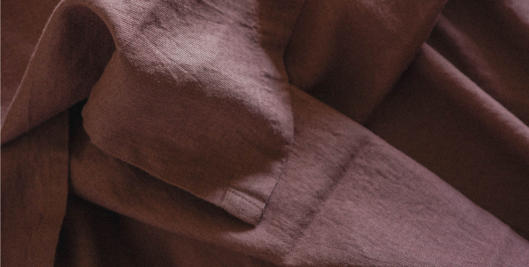A close-up of draped brown fabric with a soft, slightly textured surface.