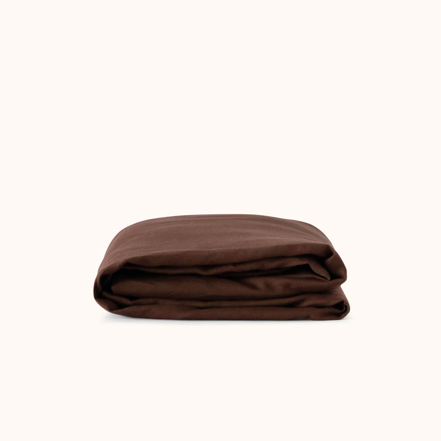 Brown fitted sheet folded neatly against a white background