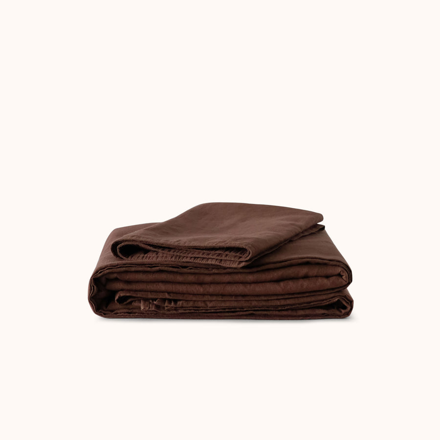 Folded brown blanket on a white background