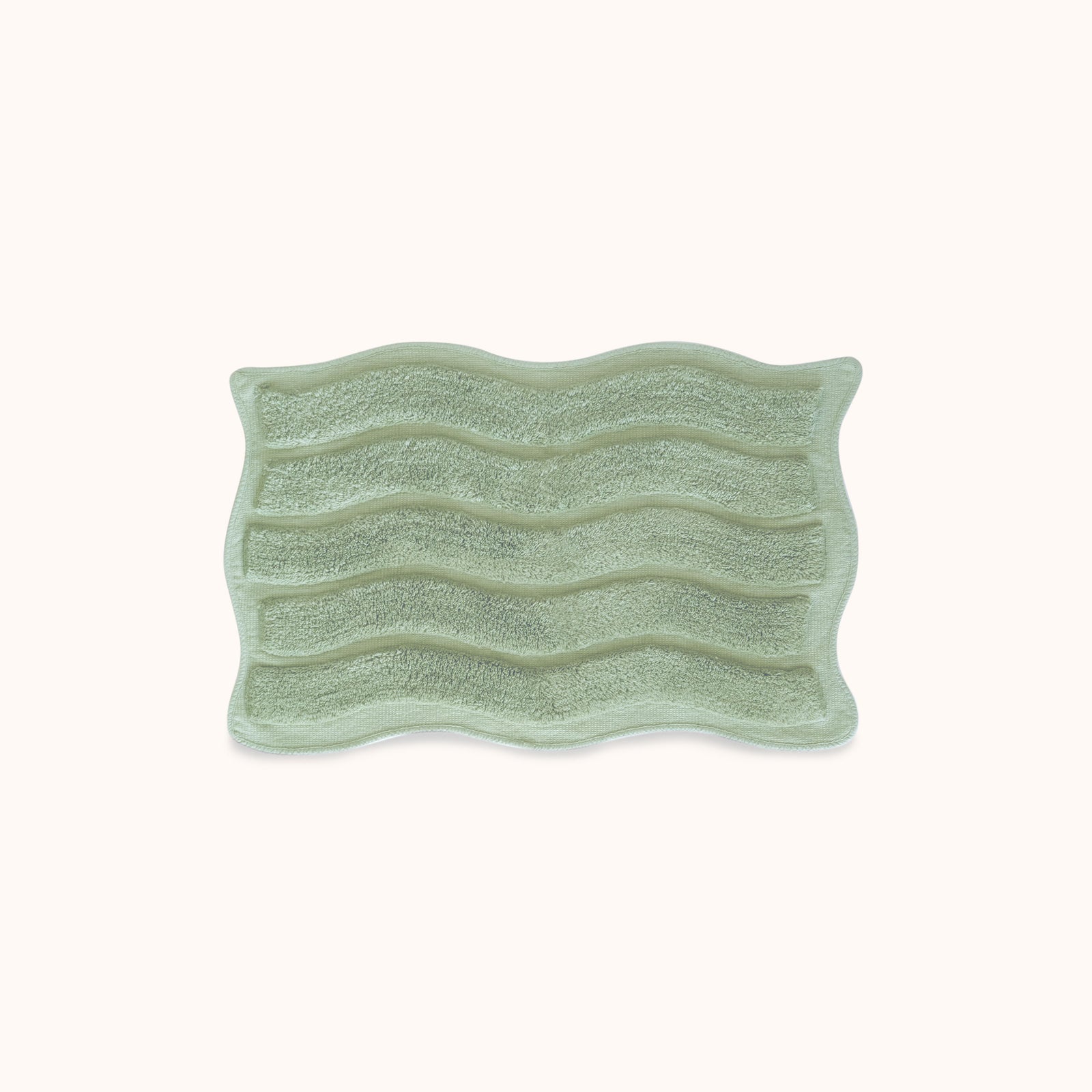 Green textured rectangular bath mat with alternating shag heights on a white background