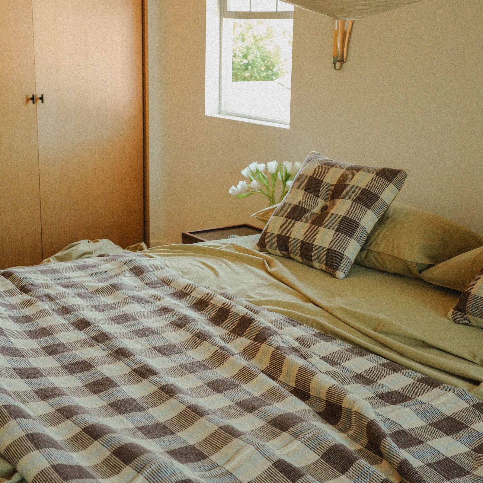 Morrow Soft Goods Pairing Mina Coverlet and Throw Pillow with Organic Percale Sheets in Pale Olive -bedroom lifestyle image.