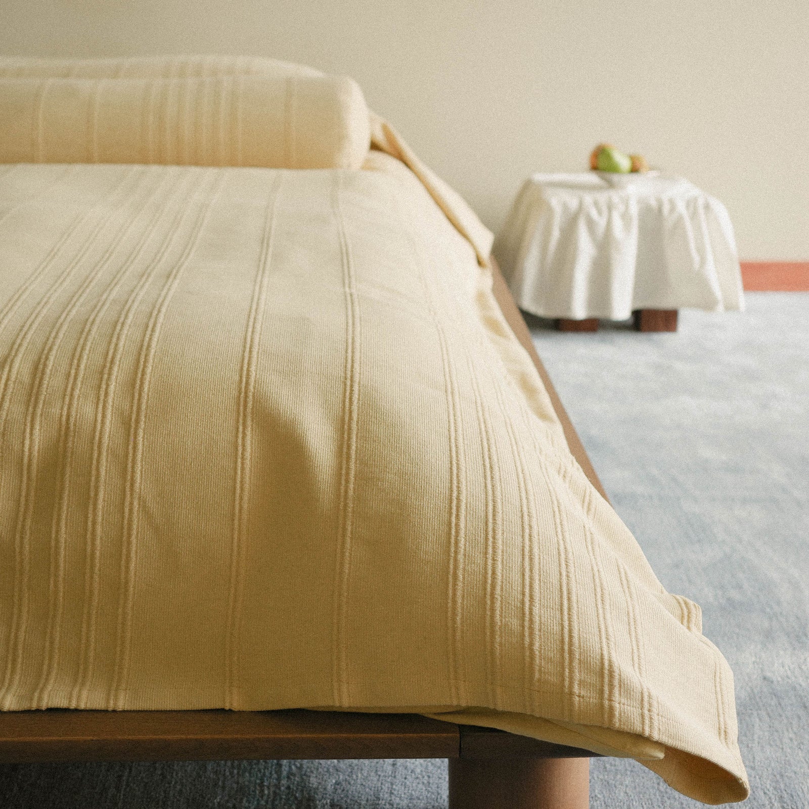 Morrow Soft Goods Devi Coverlet and Devi Bolster in Maiz - close lifestyle image