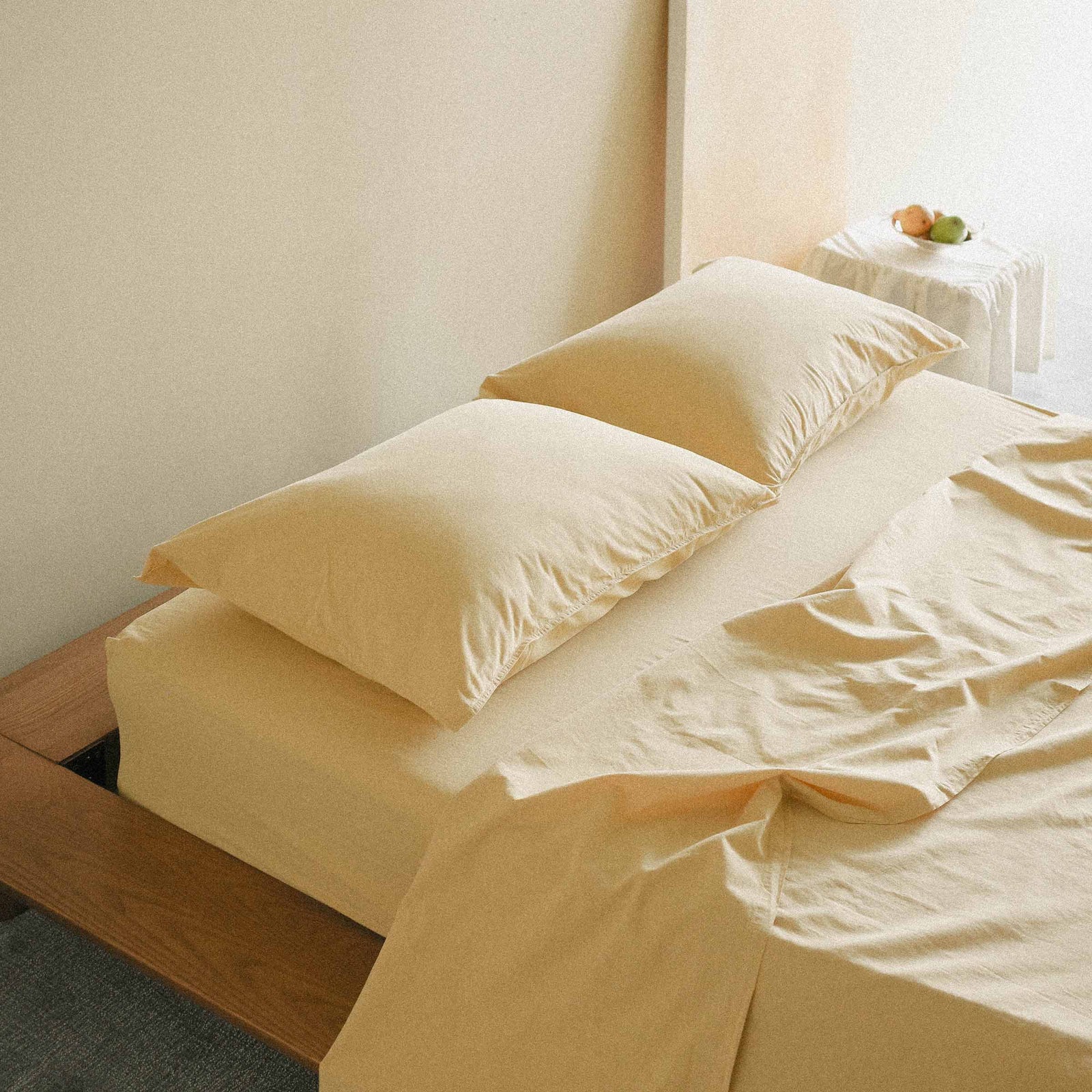 Yellow bedding set on a bed with a neutral background