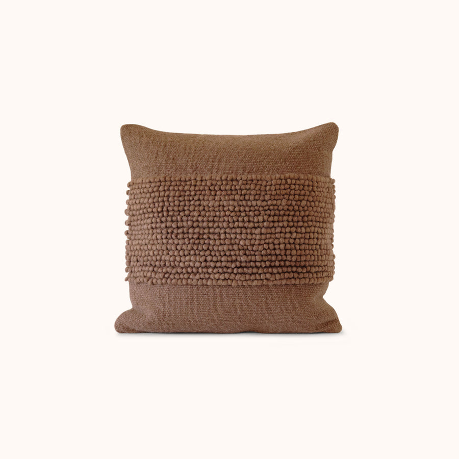 A solid brown throw pillow with a textured center design.