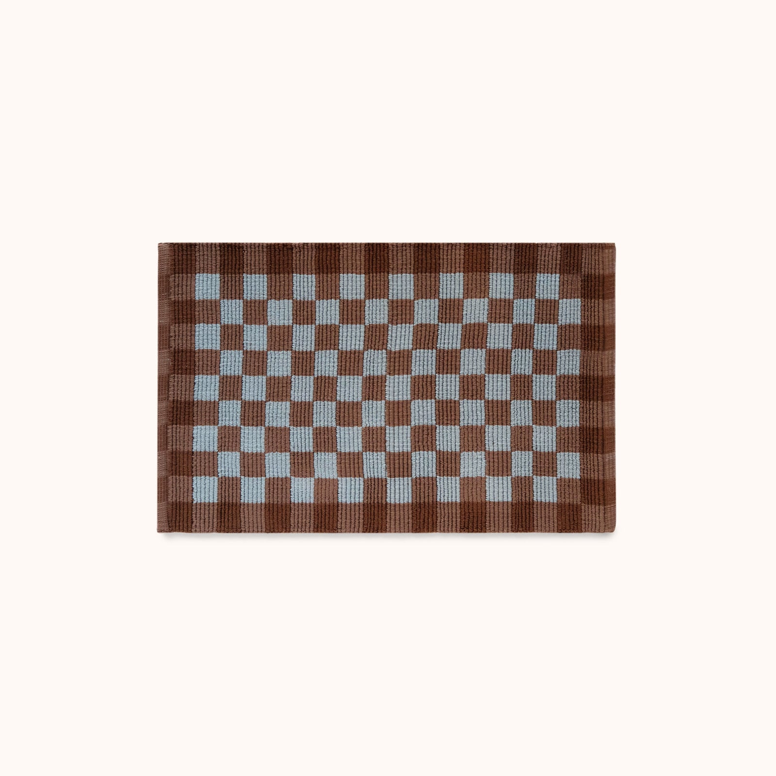 A rectangular mat with a brown and light blue checkerboard pattern, displayed flat against a solid off-white background.