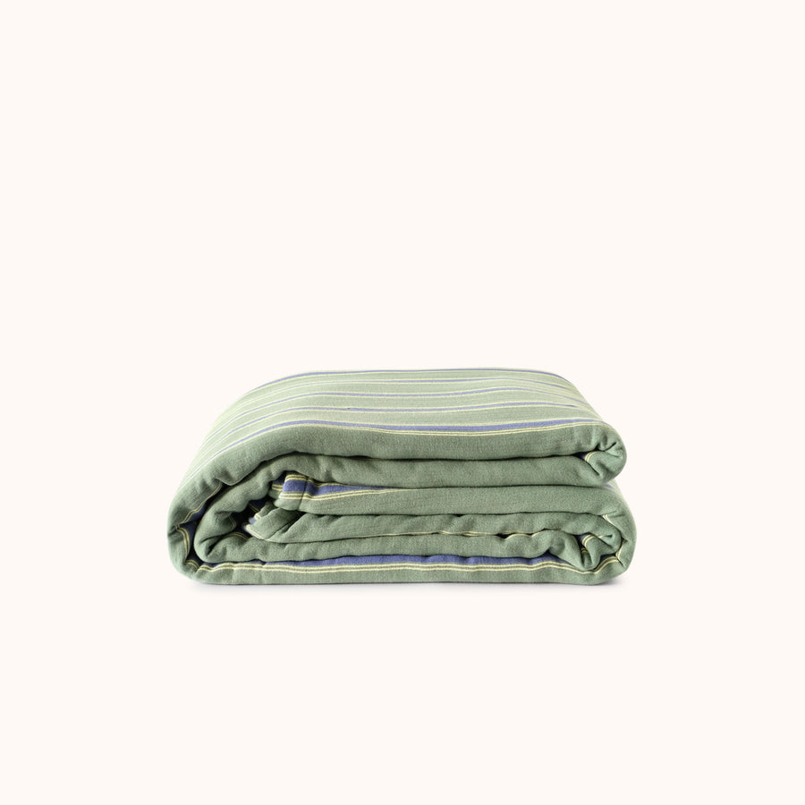 Folded green striped blanket on a white background