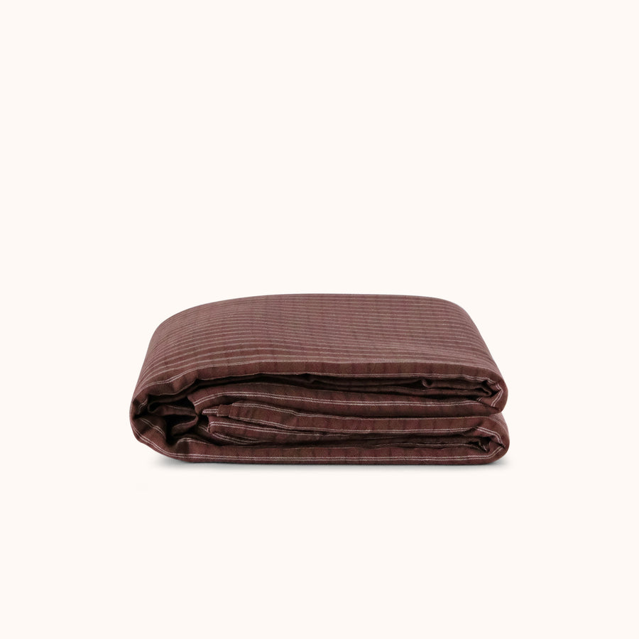 Folded brown striped duvet cover against a white background