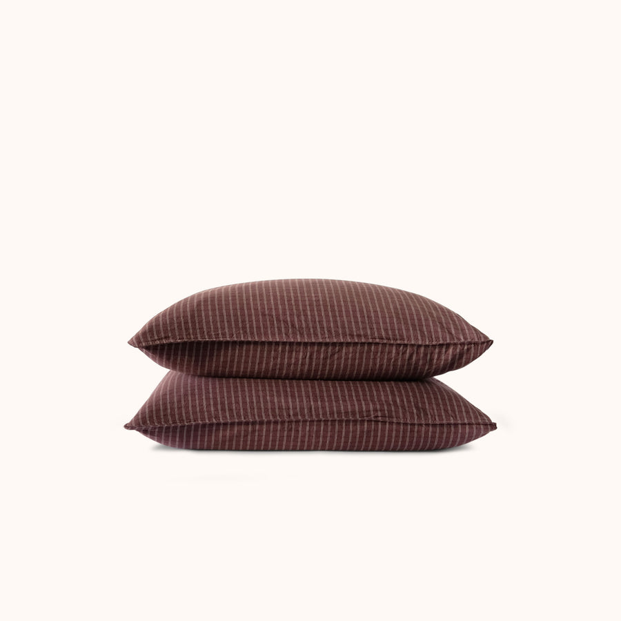 Two brown striped pillows against a white background