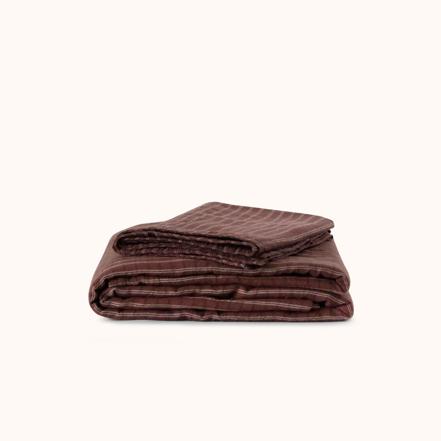 Folded striped brown sheet set against a white background