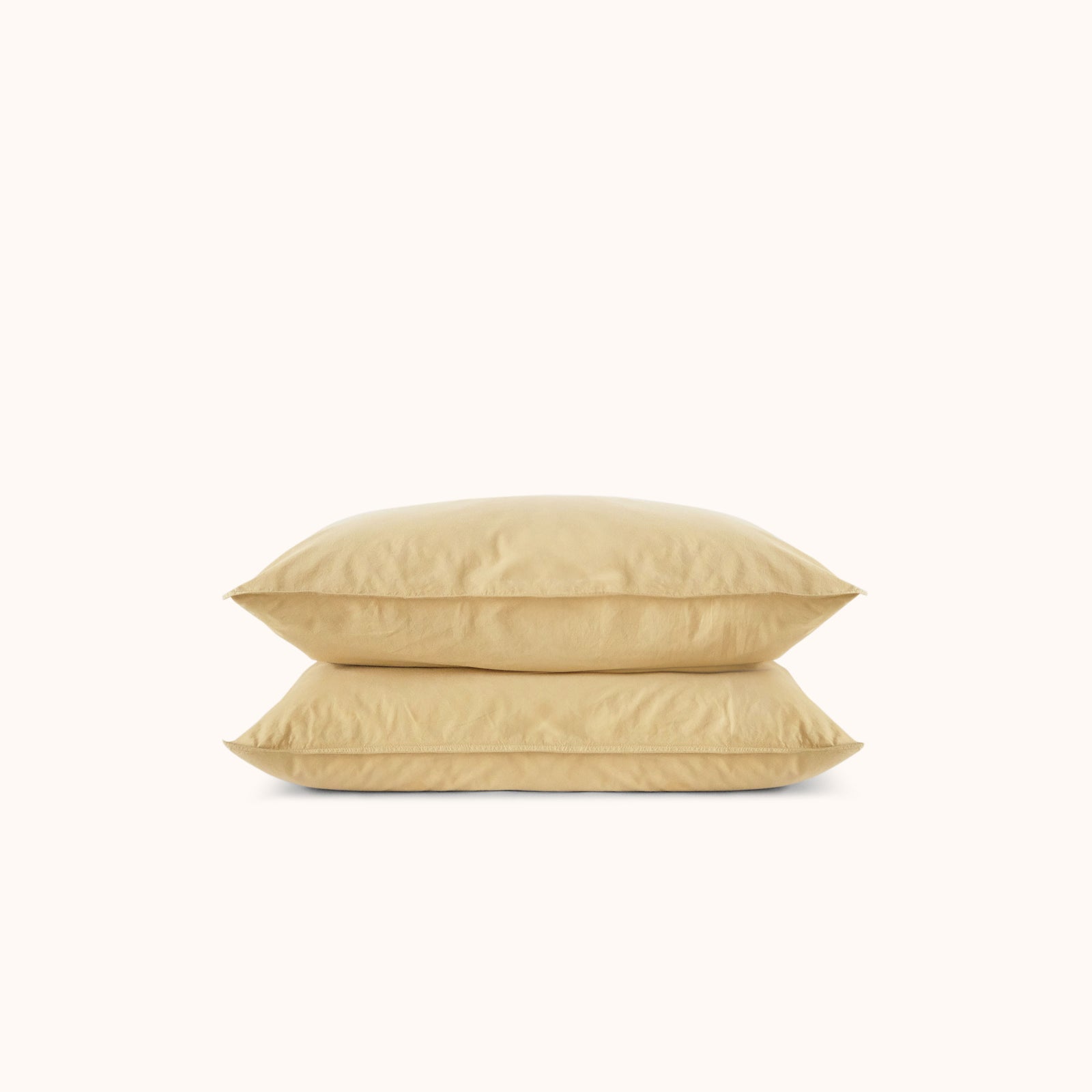 Two yellow pillows stacked on a white background