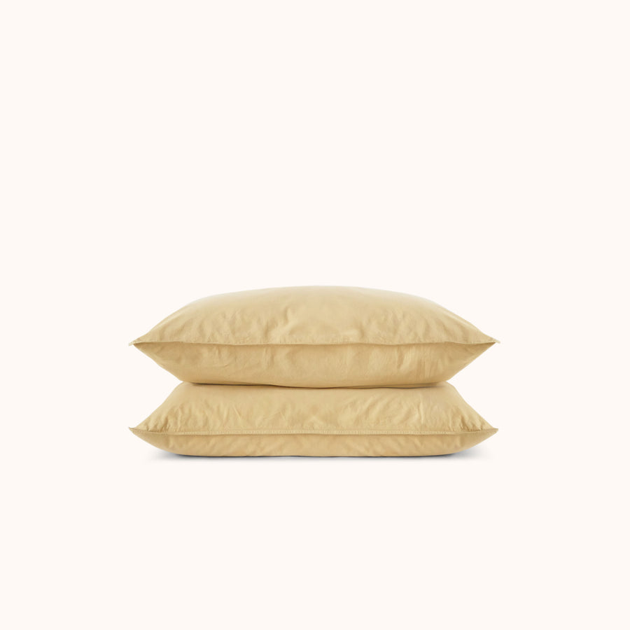Two yellow pillows stacked on a white background