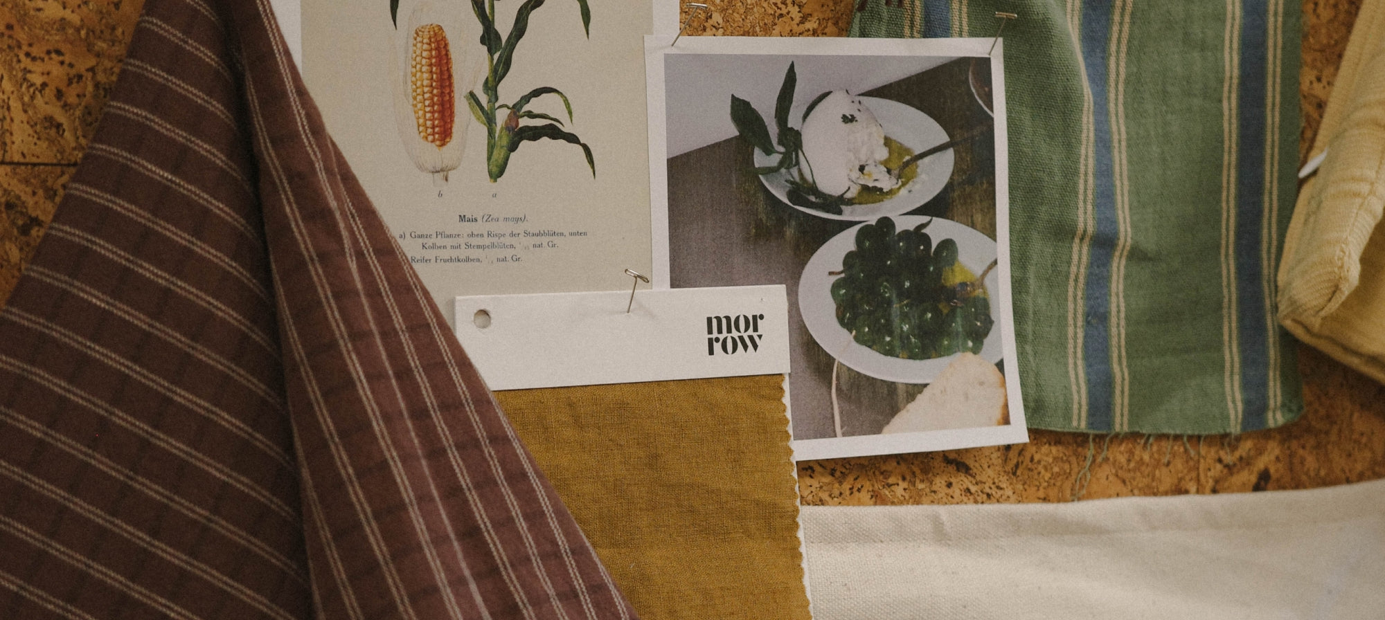 A styled flat-lay of fabric and textile swatches on a cork board.