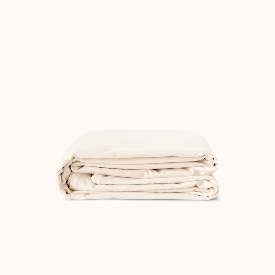 Folded cream duvet cover on a white background