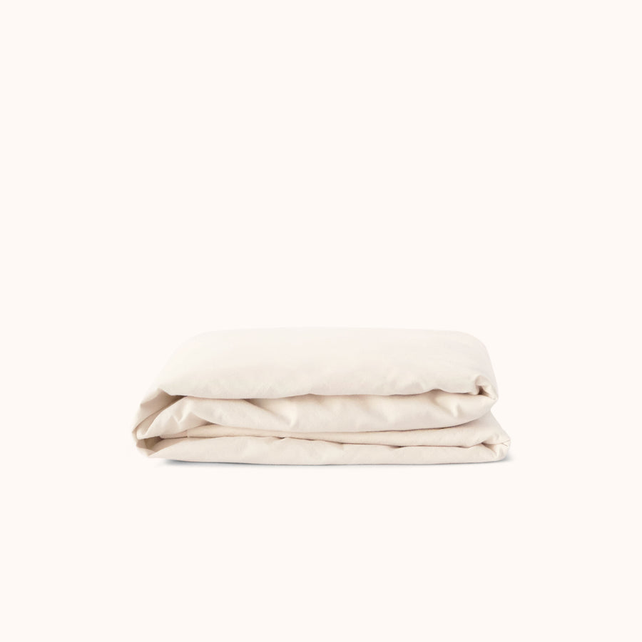Cream fitted sheet folded on a white background