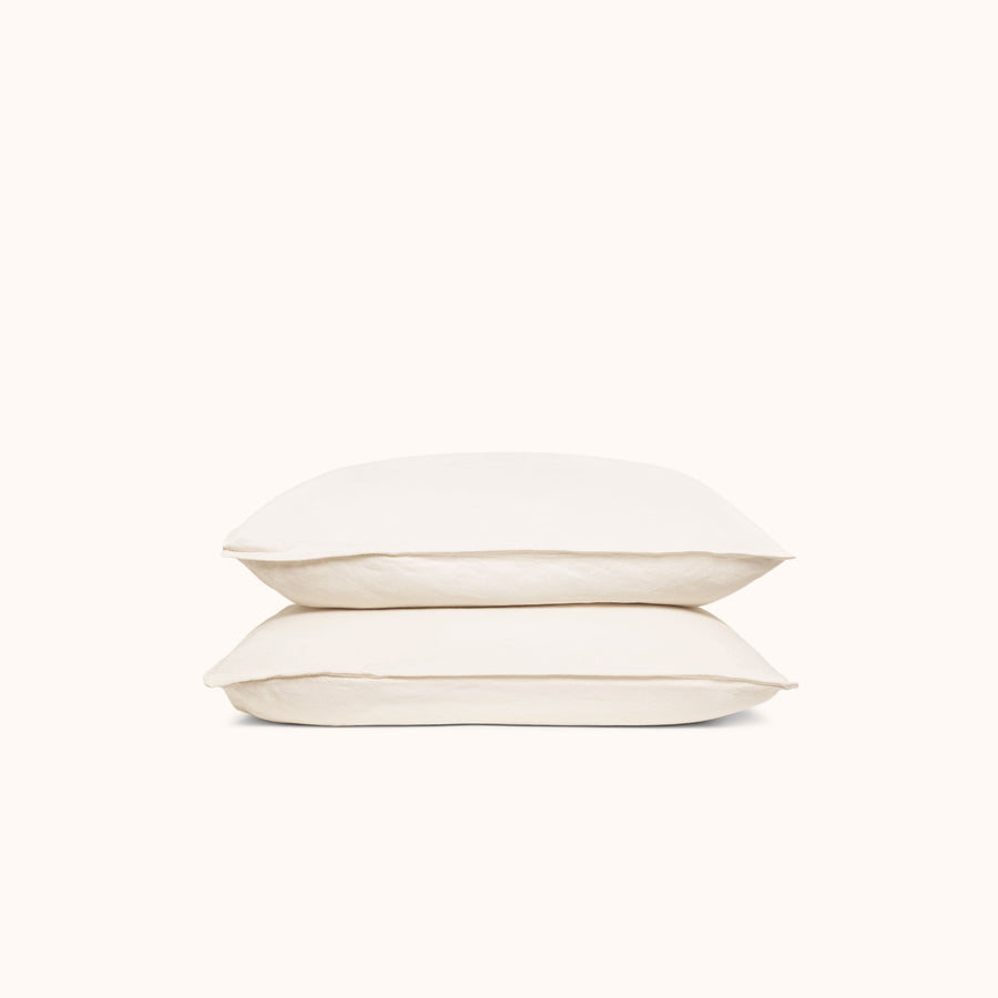 Two cream colored pillowcases stacked against a white background