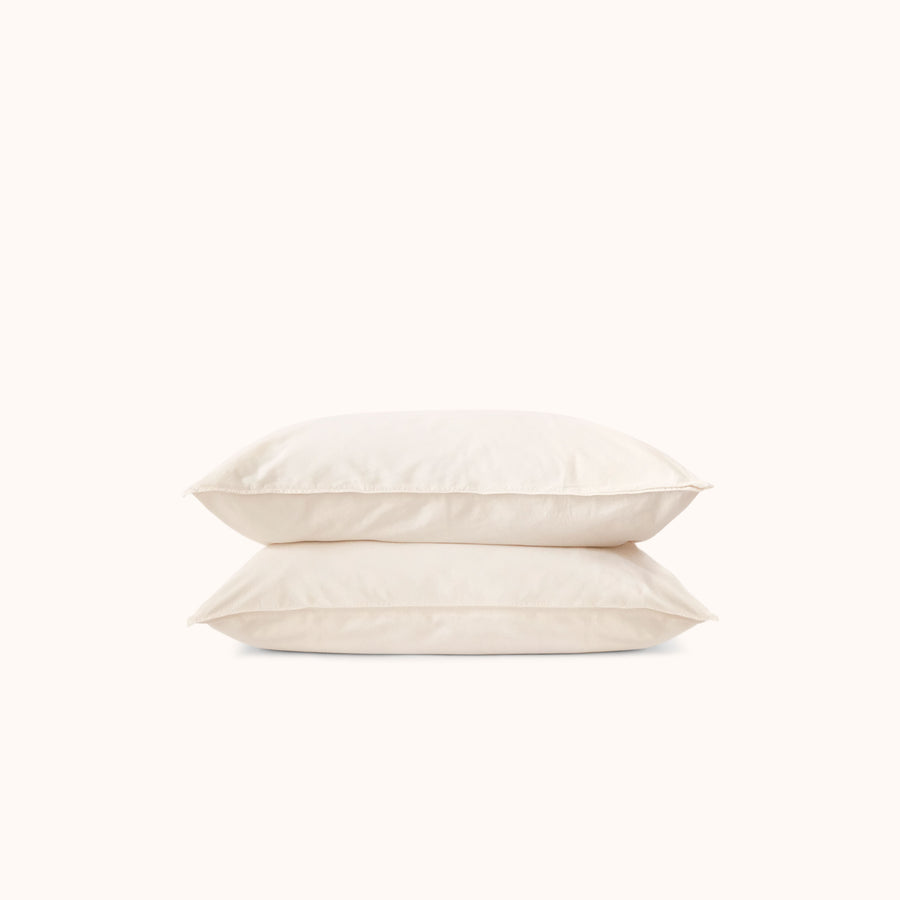 Two cream pillows stacked on a white background