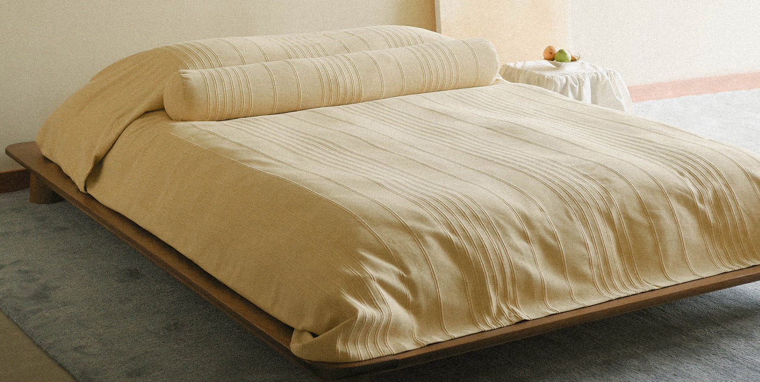 Yellow coverlet on a bed in a bedroom setting