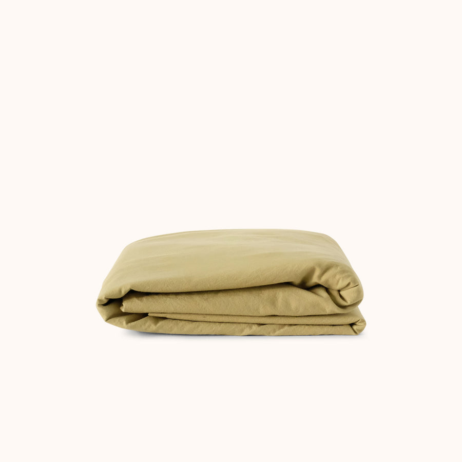 Folded green fitted sheet on a white background
