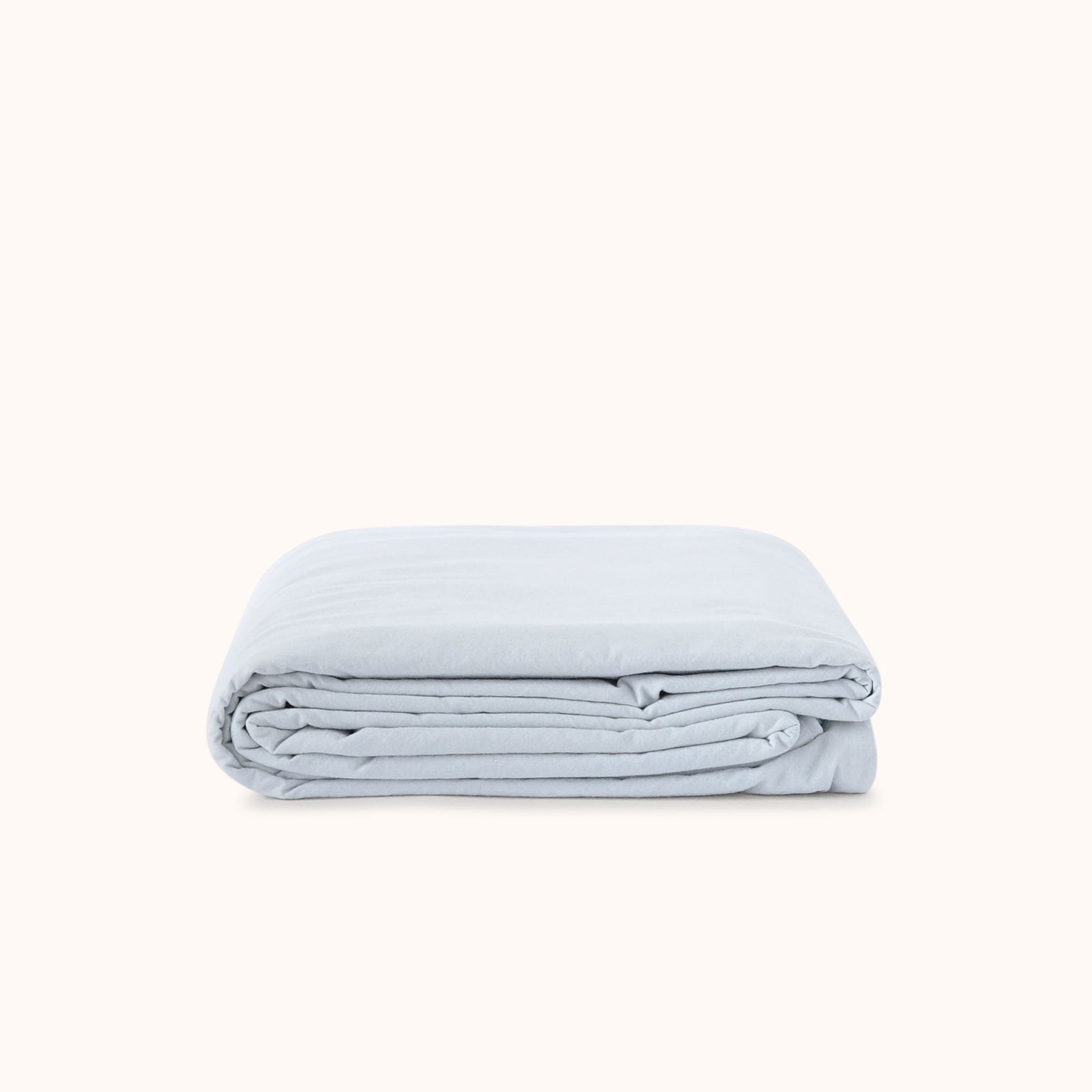 Folded light blue duvet cover on a white background