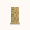 A long rectangular mat with a pale olive and light brown checkerboard pattern, displayed flat against a solid off-white background.