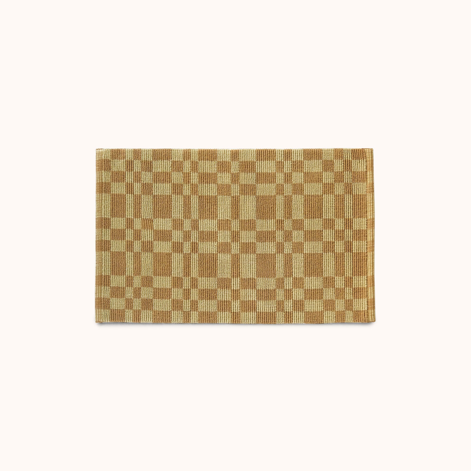 A rectangular mat with a pale olive and light brown checkerboard pattern, displayed flat against a solid off-white background.