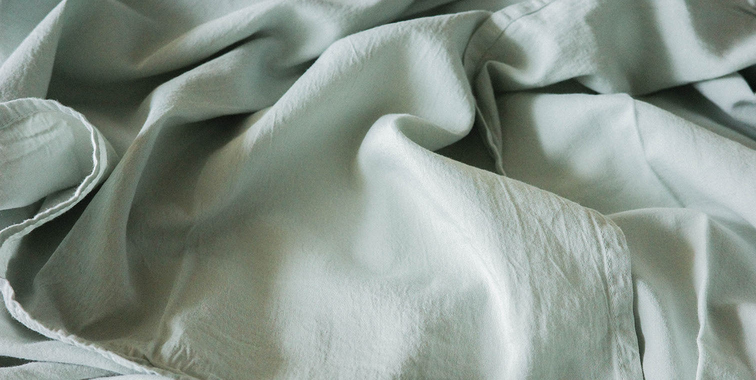 Close-up of light green fabric with folds 