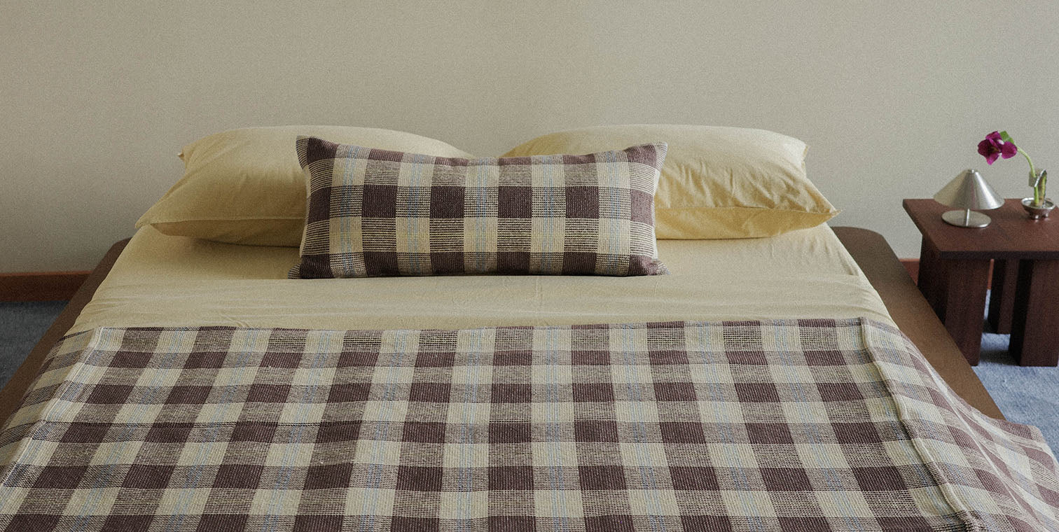 Bed with checkered blanket and pillows in a bedroom setting