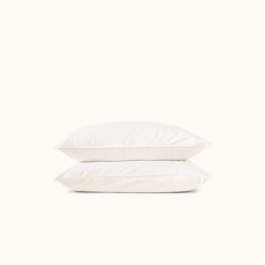 Two white pillows stacked on a white background