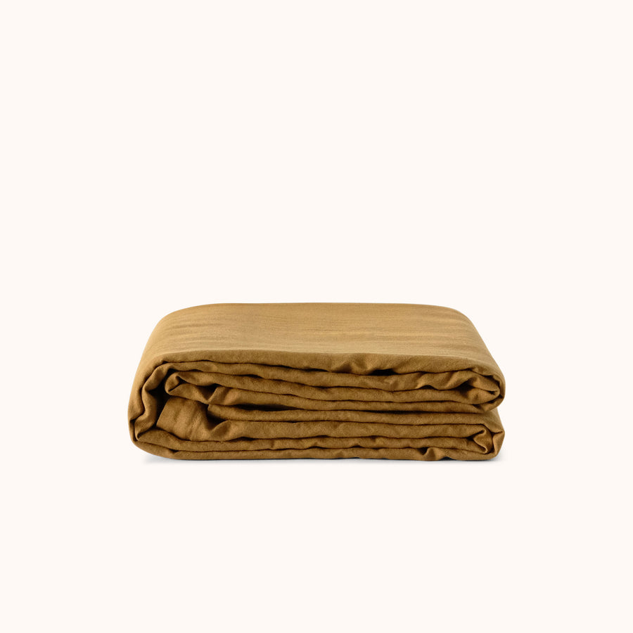 Folded brown duvet cover against a white background