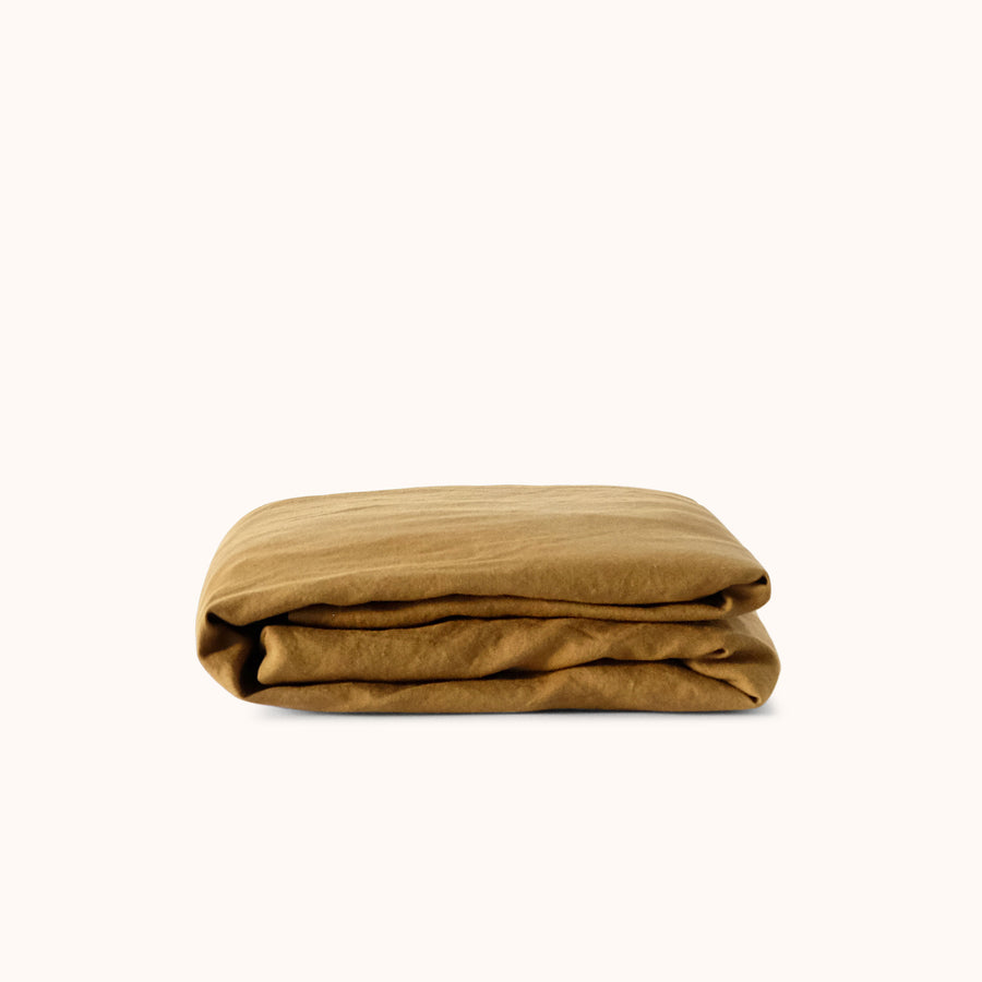 Folded brown fitted sheet against a white background