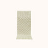 A rectangular sage green bath runner with a subtle check pattern and contrasting shag heights.