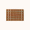 A brown bathmat with horizontal green stripes and vertical tan stripes on a white background.