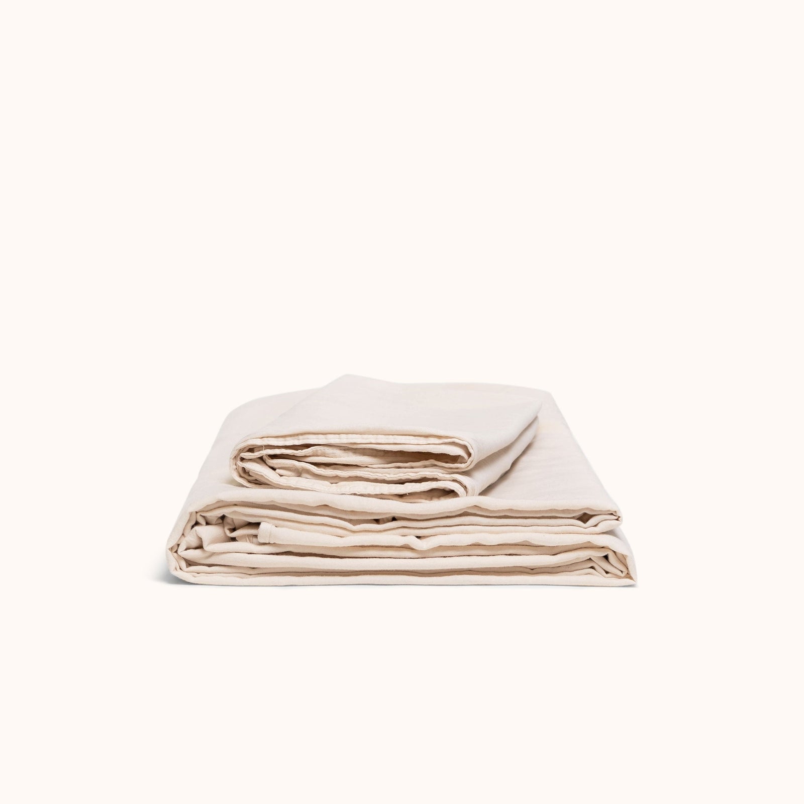 A folded sheet set in Oat organic matte sateen against a white background