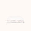 A neatly folded white matte sateen fitted sheet against a white background