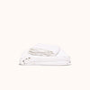 A folded white organic matte sateen sheet set against a white background