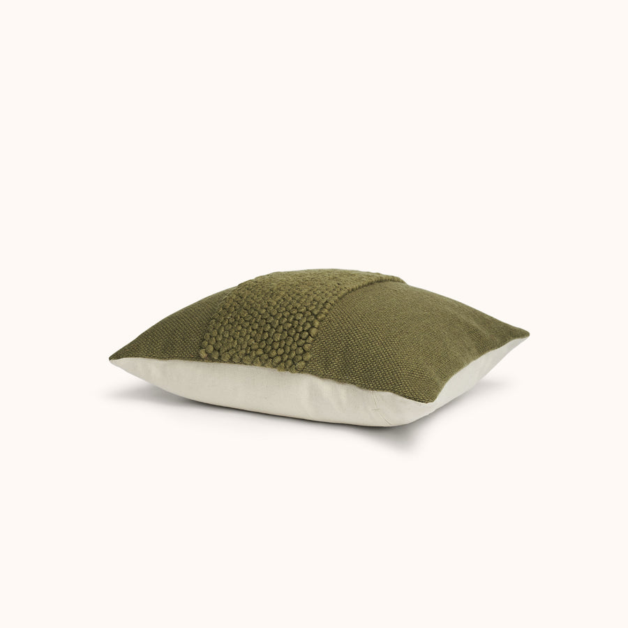 A green throw pillow with a textured band on the front and a natural colored back panel.