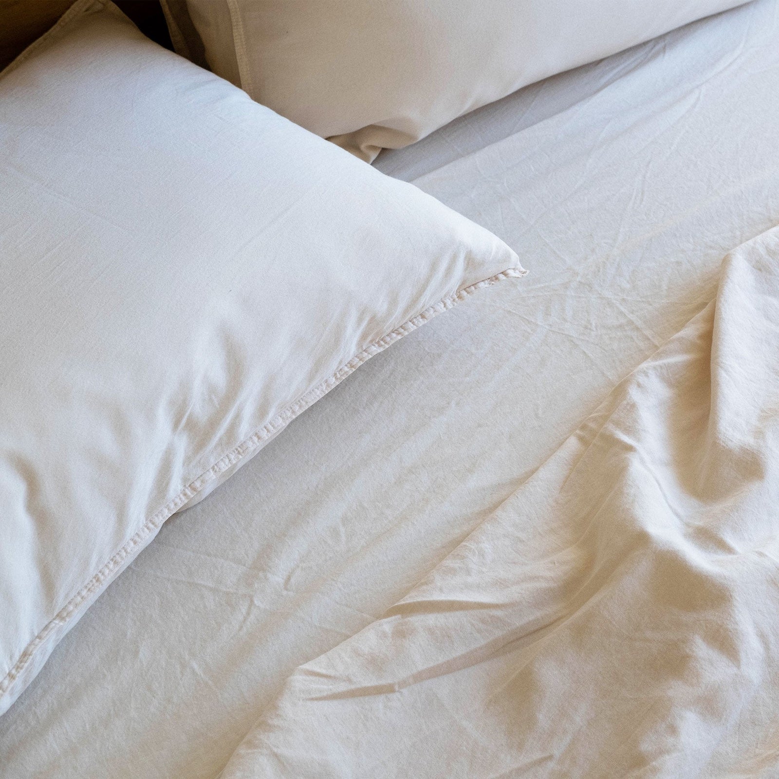 A detailed shot of Oat matte sateen sheets and pillows