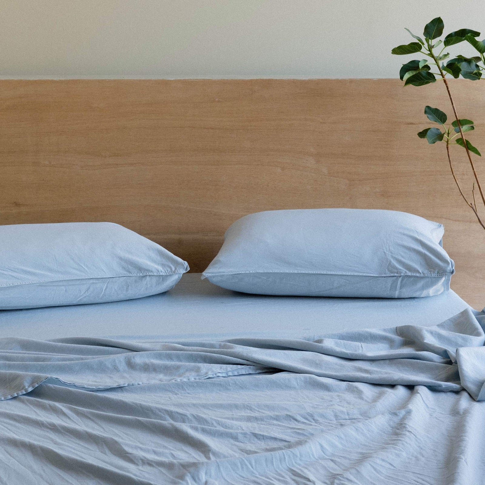 A bed made with matte sateen sheets in the color Turkish Blue. 