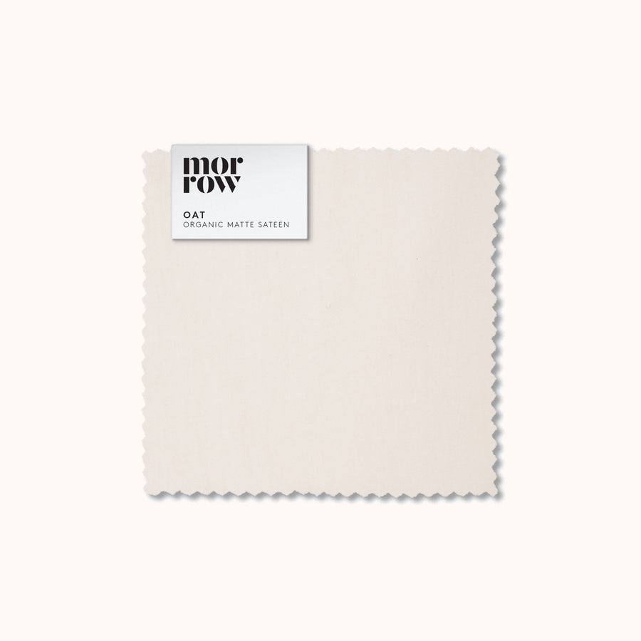 An organic matte sateen Oat fabric swatch with a Morrow label